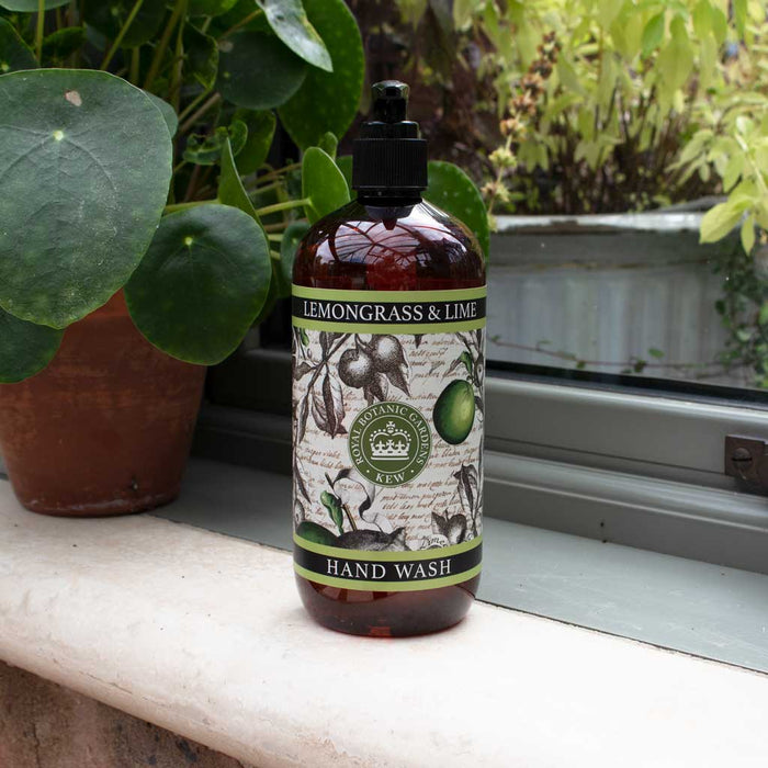 Bottle of lemongrass and lime hand wash with a Kew Gardens archival illustration label on a windowsill with plants.