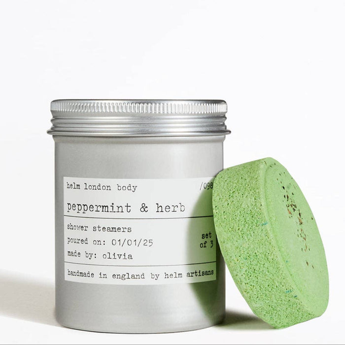 Aluminium screw top container of peppermint & herb shower steamers with a green steamer on a white background