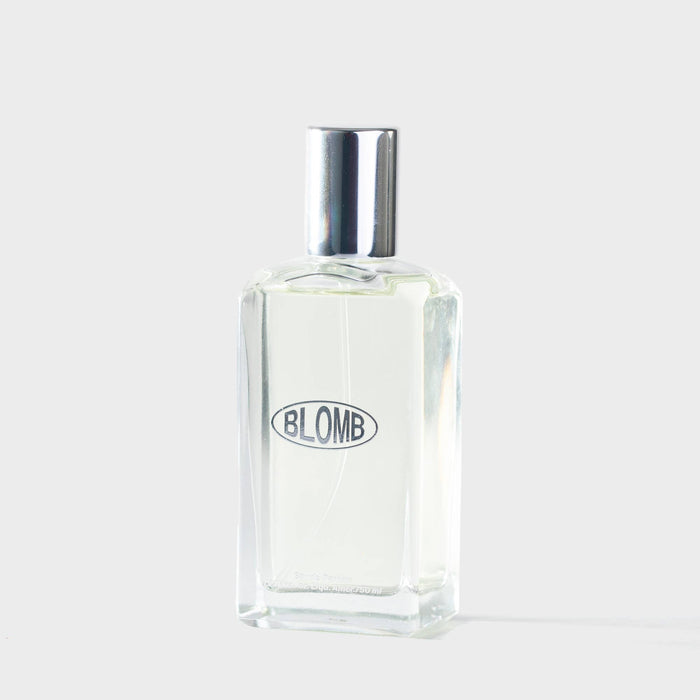 Clear glass bottle with silver cap on a white background, featuring the brand 'BLOMB'.