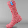 Red knitted Icelandic Saga socks with an Iceland flag brand label on a gray background. Lambswool and cotton rich to get you through the cold Arctic nights.